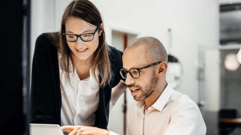 Two coworkers looking at computer screen