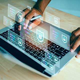 Hands holding a pen and typing on a laptop while finding out how generative AI can be used in cyber security.