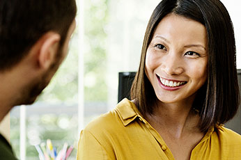 Colleague smiling and engaging in conversation during an office meeting