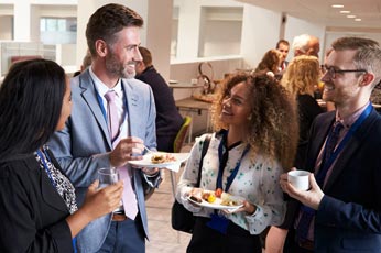 Professionals networking over food and drinks at a conference reception