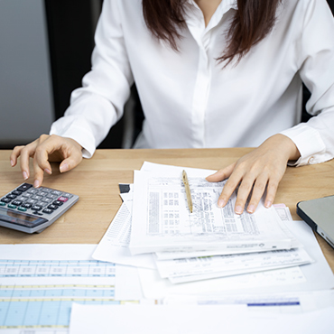 Accountant using a calculator while looking at financial statements