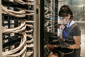 photo of woman sitting with laptop in computer room