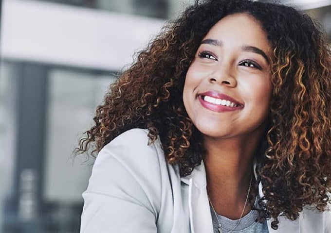 Smiling Black woman looking to her right in an office setting after earning her entrepreneurship certificate at DeVry University’s Keller Graduate School of Management.
