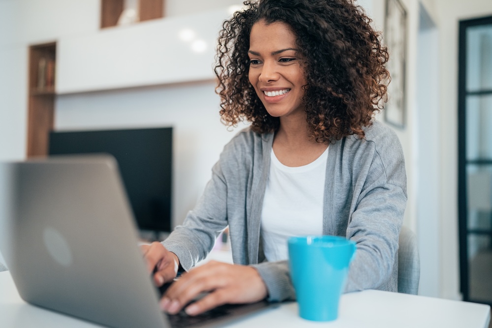Beautiful afro-american woman using laptop at home